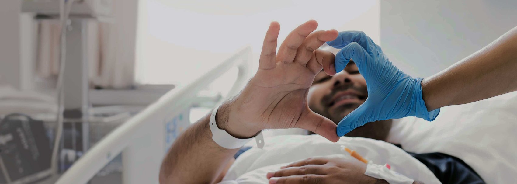 Healthcare worker and patient making a heart shape with hands